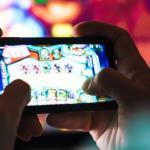 Image closeup of focused man playing video game on mobile phone